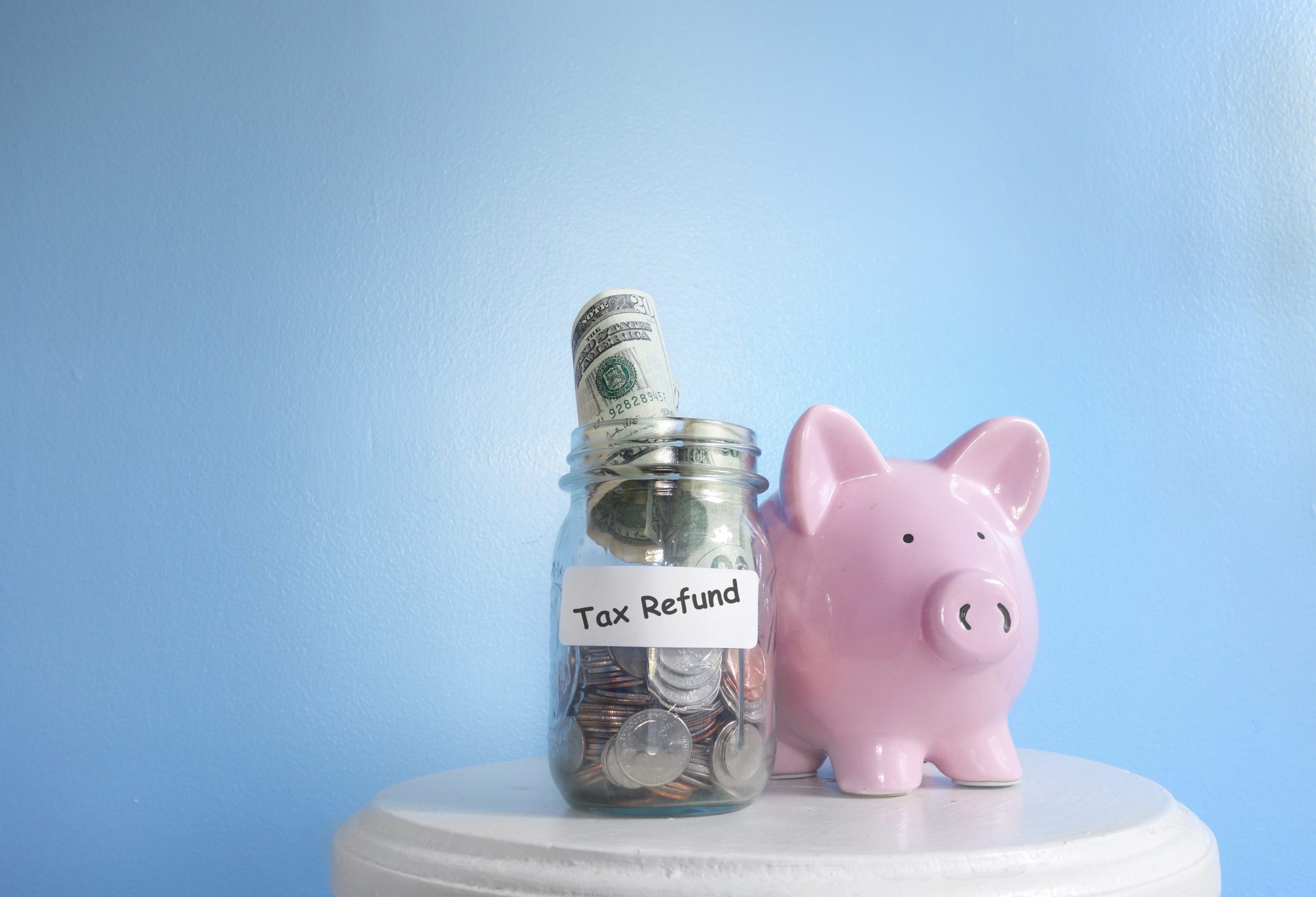 Piggy bank next to a jar of money
